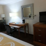 room amenities including a TV, dresser, work desk with chair, microwave and mini fridge